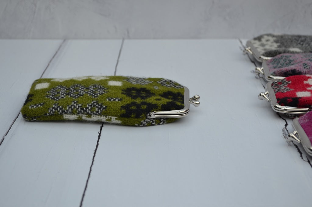 A collection of Welsh tapestry eye glasses cases with metal clasp, displayed on a white surface. The cases feature various traditional Welsh patterns and colours.