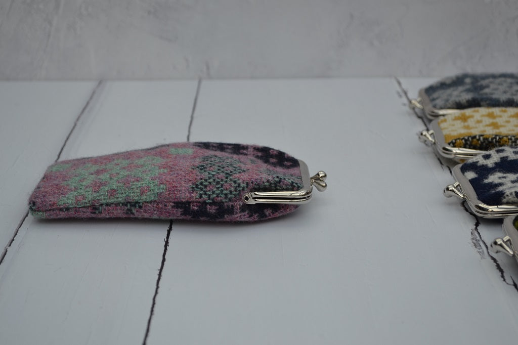 A collection of Welsh tapestry eye glasses cases with metal clasp, displayed on a white surface. The cases feature various traditional Welsh patterns and colours