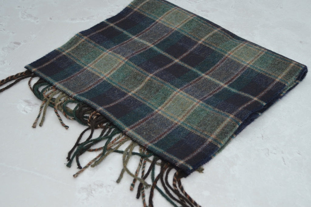 Plaid scarf with fringes on a textured surface