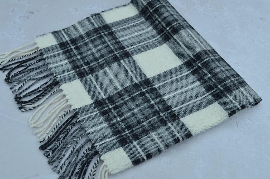 Plaid scarf with tassels on a light gray background